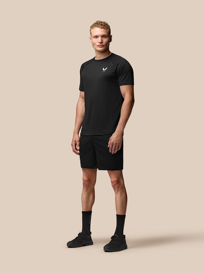Full body model wearing black Adapt Training Shorts with matching top for an athletic workout look
