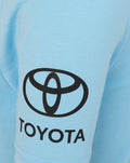 Close-up of light blue fabric with a large Toyota logo on the chest
