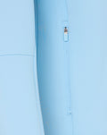 Close-up of light blue hoodie side zipper pocket with pull tag.