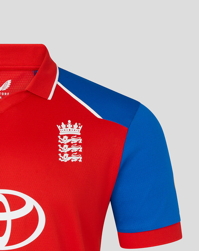 Chest close-up of red T20 Pro shirt featuring the white England crest and blue sleeve.