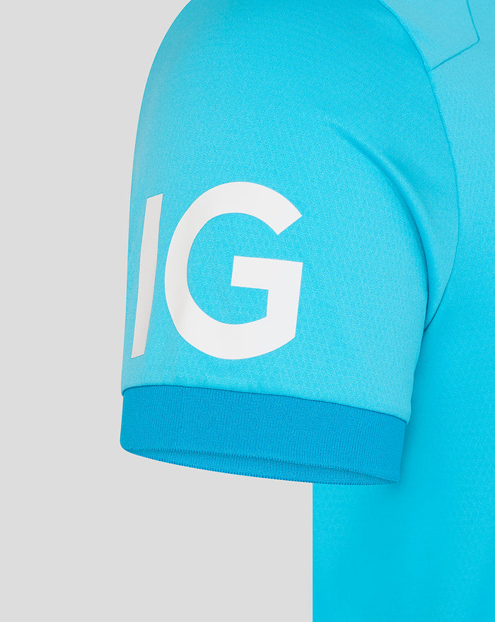 Close-up of sleeve on turquoise ODI Pro shirt with large white IG letters.
