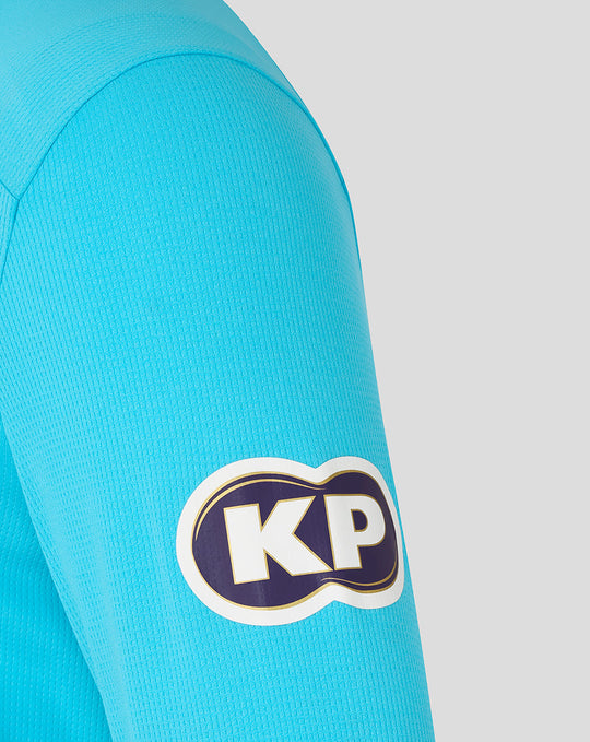 Close up of blue ODI long sleeve shirt sleeve with a KP logo patch.