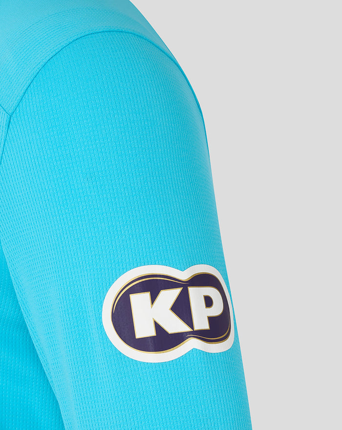 Close up of blue ODI long sleeve shirt sleeve with a KP logo patch.
