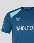 Blue training jersey close-up showing the England crest on the chest and Castore branding along the collar