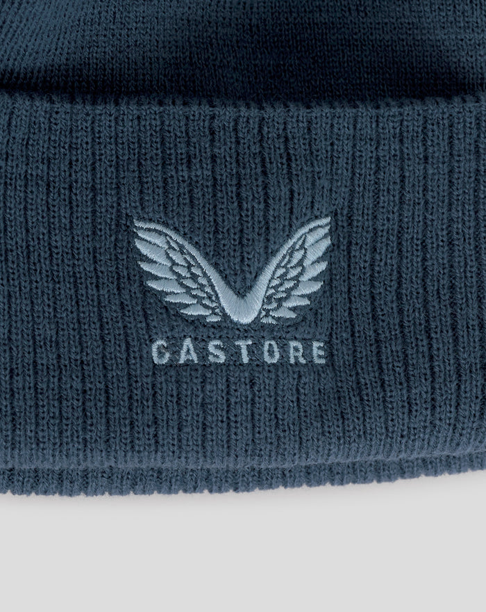 Close up of a dark blue knit bobble hat with light blue Three Lions crest embroidery