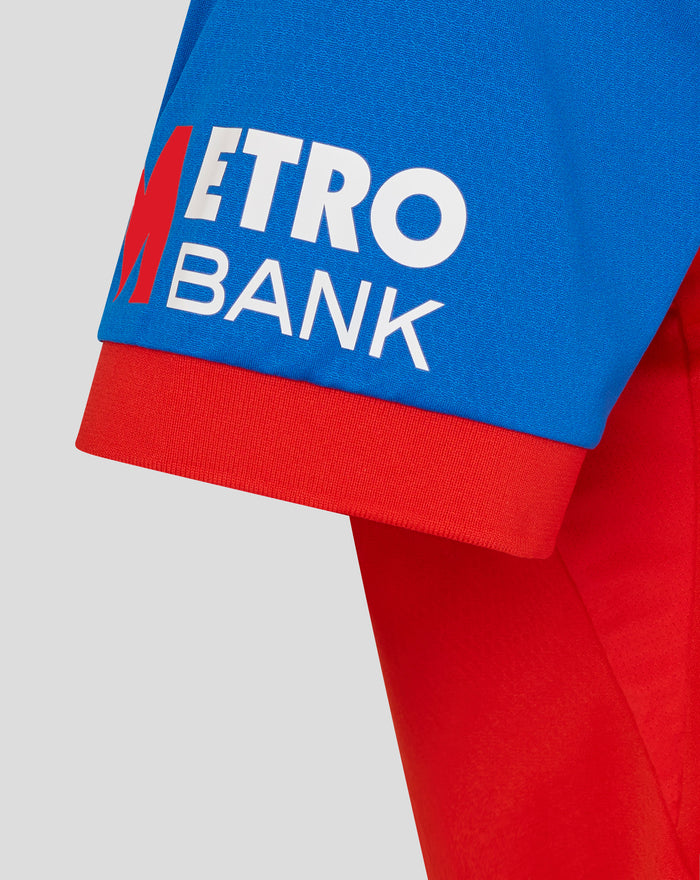 Close-up of blue chest panel with METRO BANK in white on red cricket shirt
