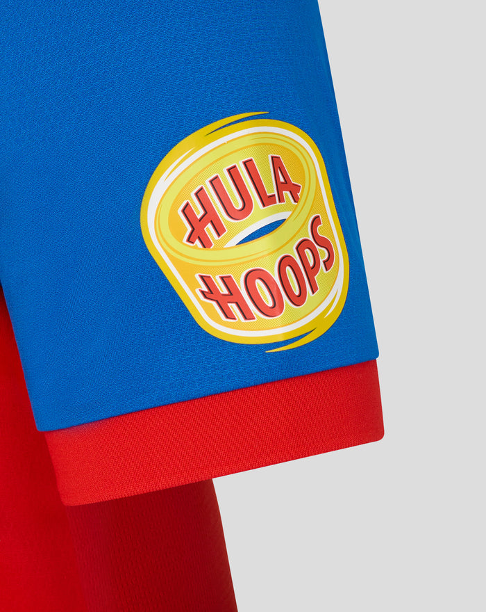 Close up of blue T20 pro shirt sleeve featuring a yellow circular HOOLA HOOPS logo on the red hem
