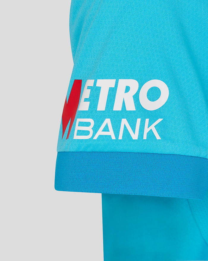 Womens ODI Pro short sleeve blue shirt close-up showing Metro Bank logo on the front hem.