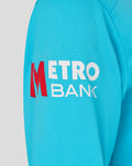 Close-up of blue sleeve with Metro Bank logo in white and red