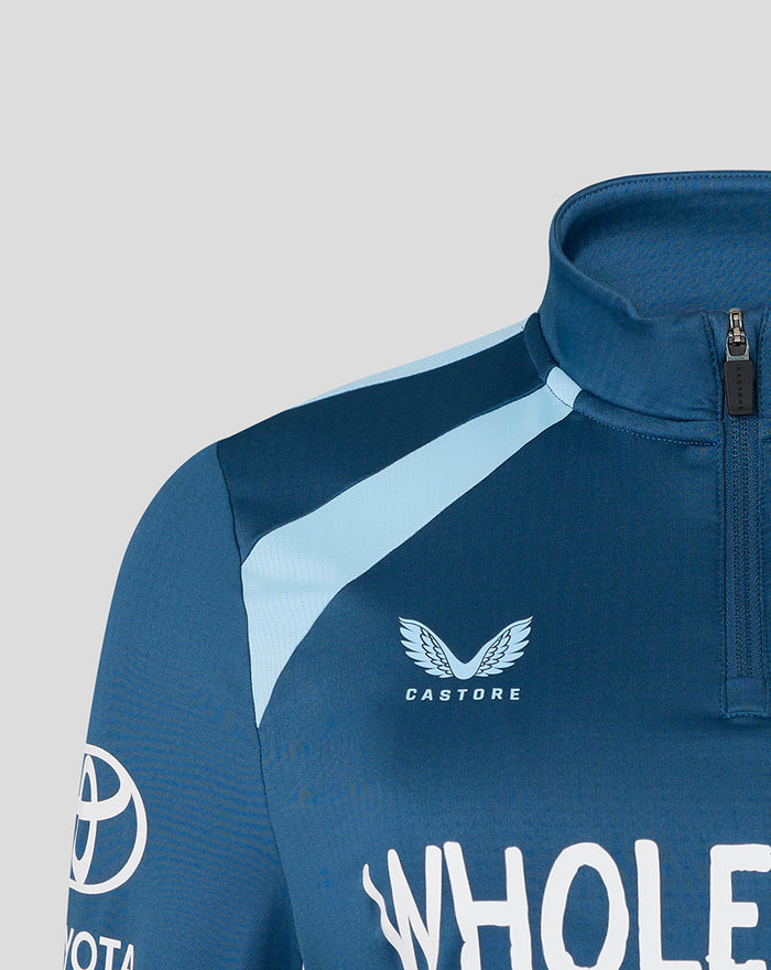 Front close-up of blue training midlayer chest with Castore emblem.
