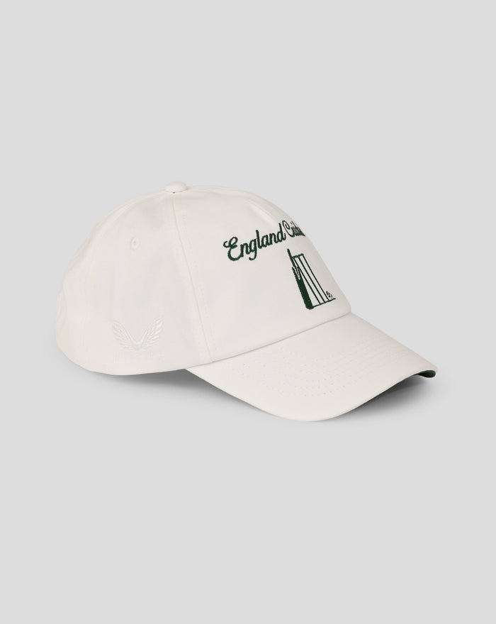 White cap displaying a large bold green emblem on the front and a curved brim