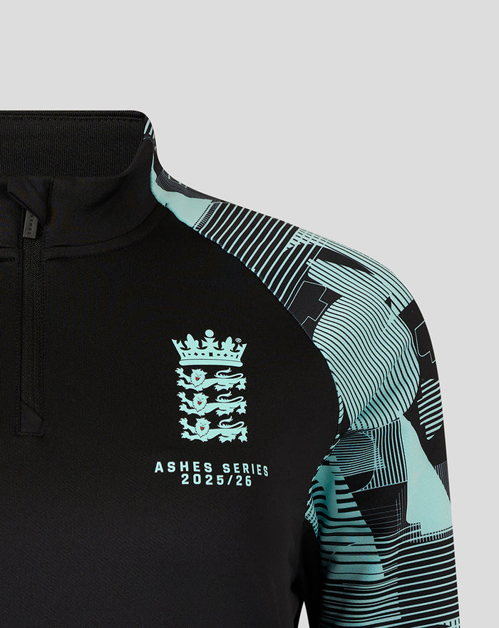 Close up of the front of the black England Ashes training top showing the crest on the chest and Castore logo in teal
