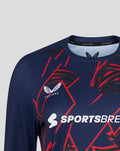 Close up of navy long sleeve performance T-shirt showing bold red geometric pattern and branding.
