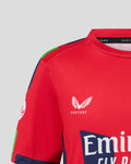 Front view of red junior T20 jersey showing Emirates branding across chest and Castore wing emblem on left chest.