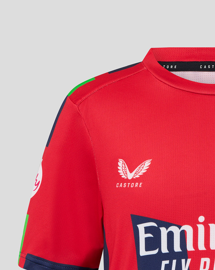 Front view of red junior T20 jersey showing Emirates branding across chest and Castore wing emblem on left chest.