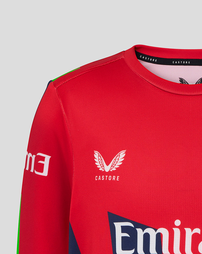 Front view of red junior T20 jersey with Emirates logo and wing emblem and green panel details