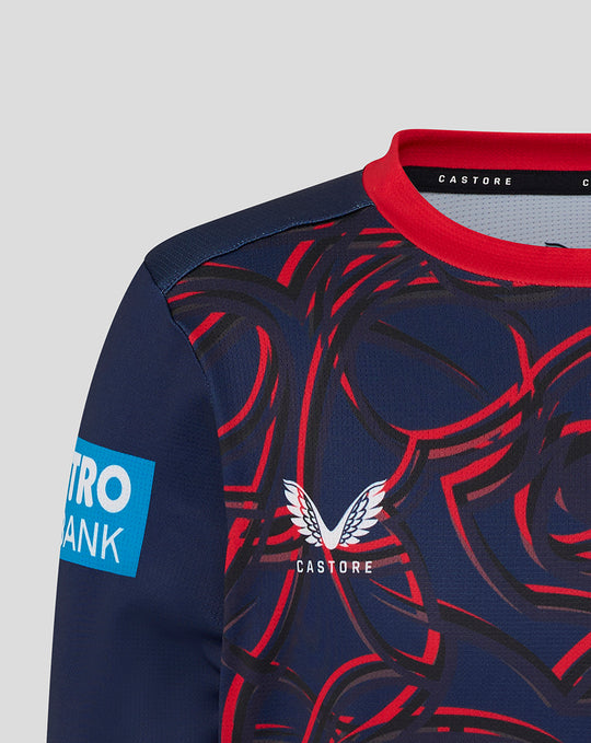 Close-up of navy Junior One Day Long Sleeve Jersey in Peacoat with red collar, bold red swirl pattern, Castore branding and Lancashire Cricket crest