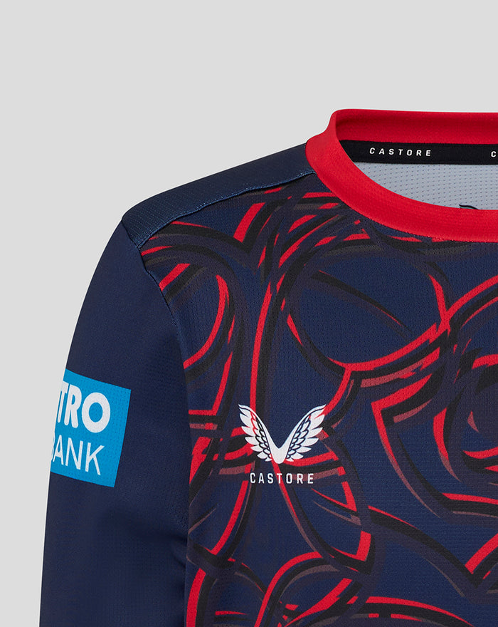 Close-up of navy Junior One Day Long Sleeve Jersey in Peacoat with red collar, bold red swirl pattern, Castore branding and Lancashire Cricket crest