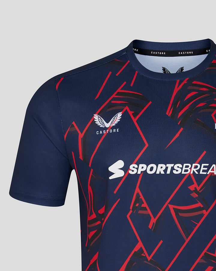 Close-up of navy performance T-shirt with bold red geometric graphics, Lancashire Cricket crest and Sportsbreaks logo