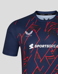 Close-up of navy performance T-shirt with bold red geometric graphics, Lancashire Cricket crest and Sportsbreaks logo