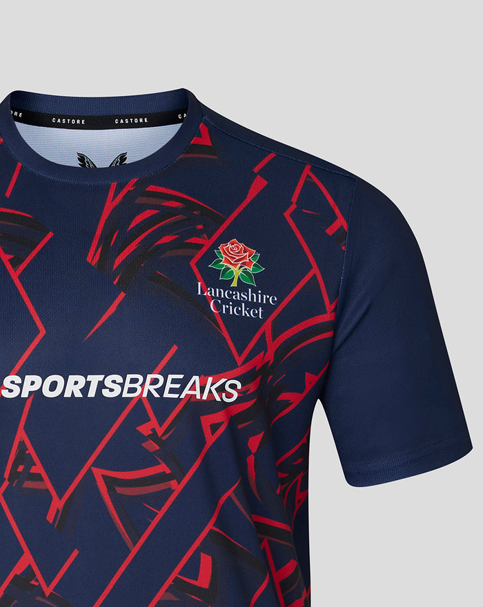 Shoulder and chest close-up of navy T-shirt showing red geometric pattern and Sportsbreaks branding with Lancashire Cricket emblem
