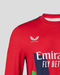 Red sweatshirt chest showing Castore emblem and Emirates Fly Better branding with navy and green graphics.