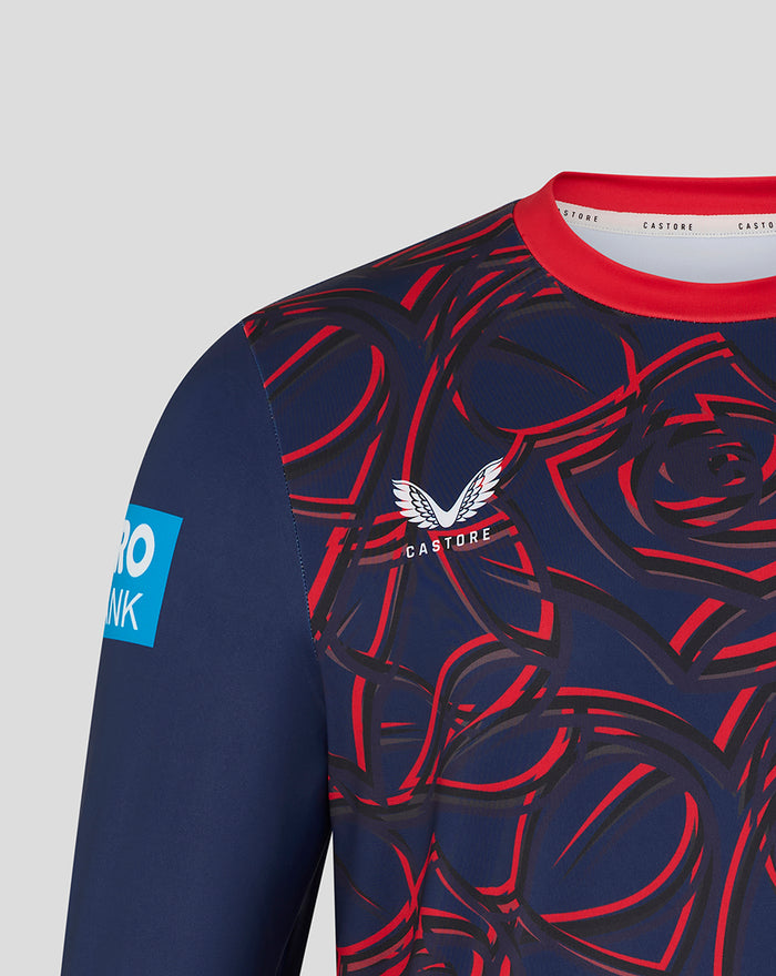 Close-up of navy athletic top shoulder with red abstract pattern and white Castore wing logo.