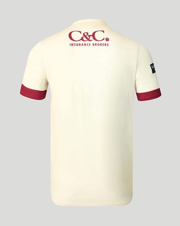 Back view of cream County Champs short sleeve jersey with C&C Insurance Brokers logo on the upper back and red sleeve trim