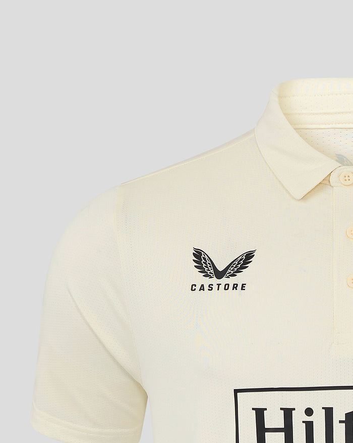 Close up of Castore logo on the front left chest of the beige jersey